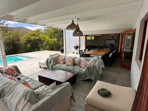 a living room with couches and a table and a pool at Barrydale Bliss in Barrydale