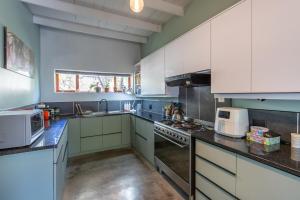 a large kitchen with white cabinets and appliances at Barrydale Bliss in Barrydale