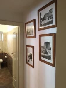 a bathroom with pictures hanging on the wall at Delightful apartment 100 meters from the Colosseum in Rome