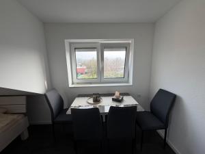 a table and chairs in a room with a window at Ferienwohnung Verissimo in Ittlingen