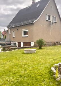 a large house with a grass yard with a house at Ferienhaus in Glauchau, Garten, Grillmöglichkeit, Privatparkplatz, Kaffeevollautomat, Wlan, Netflix in Glauchau