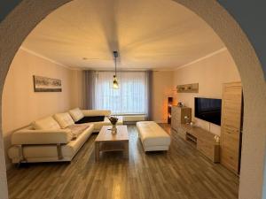 a living room with a couch and a tv at Ferienhaus in Glauchau, Garten, Grillmöglichkeit, Privatparkplatz, Kaffeevollautomat, Wlan, Netflix in Glauchau