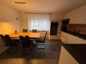 a kitchen with a table and chairs in a room at Ferienhaus in Glauchau, Garten, Grillmöglichkeit, Privatparkplatz, Kaffeevollautomat, Wlan, Netflix in Glauchau