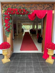 a corridor with red flowers and a red carpet at Kitulgala Ebony Riverside Resort in Kitulgala