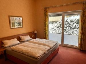 a bedroom with a bed and a window at Landhotel Ritter-Post in Angelbachtal