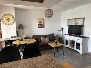 a living room with a couch and a tv at Residence Los Jardines in Alcossebre
