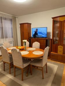 a dining room with a table and a television at Apartment OrMarić in Otočac