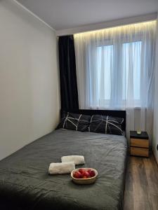 a bedroom with a bed with a bowl of fruit on it at Vistula Center in Płock