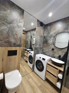 a bathroom with a washing machine and a washer and dryer at Vistula Center in Płock