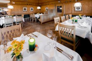 restauracja z białymi stołami i krzesłami oraz świecą w obiekcie Landhotel Tirolerhof - Wildschönau - PREMIUM Card im Sommer w mieście Oberau