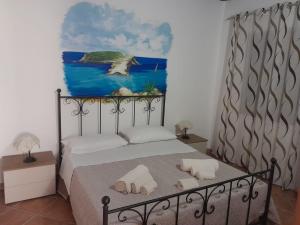 a bedroom with a bed with a painting on the wall at Il Sole Di Lampedusa in Lampedusa