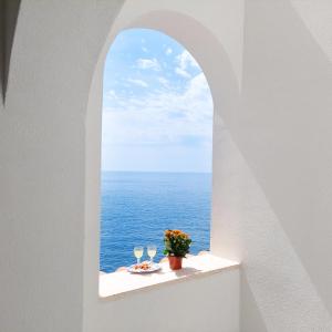 a table with a view of the ocean through an archway at Casa Gianna New 2026 in Praiano
