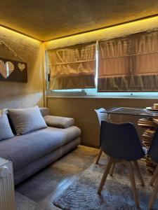 a living room with a couch and a desk at D&P Cell Oneiro. in Kalavrita