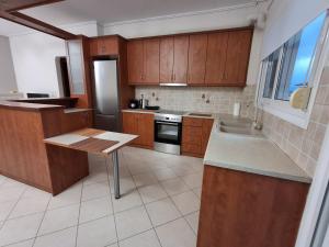 a kitchen with wooden cabinets and a sink and a stove at Marbi Apartment in Tripoli +7 photos