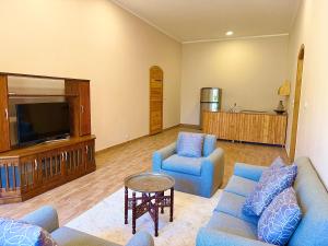 a living room with two blue couches and a tv at Citadel Luxor in Luxor