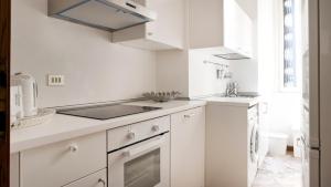 a white kitchen with a sink and a stove at Italianway-Colonnetta in Milan