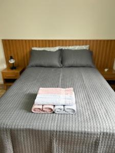 a bed with two towels and two pillows on it at Apartamento 1 quarto, sala e cozinha próximo ao Aeroporto in Vitória