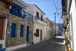 an alley with white buildings and blue windows at Sokaki in Kokkari