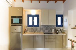 a kitchen with white cabinets and a refrigerator at Sokaki in Kokkari +7 photos