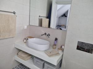 a white bathroom with a sink and a mirror at Sokaki in Kokkari