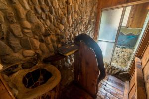 Baño de piedra con aseo y ventana en Hotel Roca Dura, en Herradura