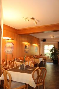uma sala de jantar com mesas e cadeiras de madeira em Landhaus Hotel Müller em Ringheim