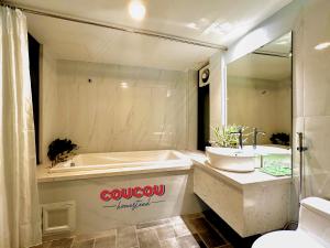 a bathroom with a tub and a sink and a bath tub at CouCou Homestead II - Mini Hotel District 1 in Ho Chi Minh City