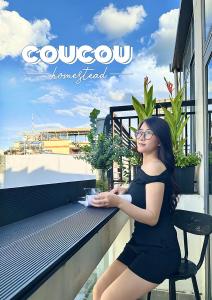a woman in a black dress sitting on a bench at CouCou Homestead II - Mini Hotel District 1 in Ho Chi Minh City