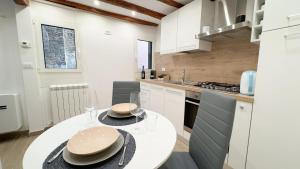 a kitchen with a white table with two plates on it at Maison Studio in Chioggia