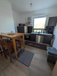 a kitchen with a wooden table and a kitchen with a sink at Hehlentor-City Gäste Wohnung in Celle