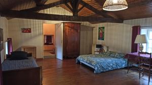 a bedroom with a bed and a table and a chair at La Roche Cantin in Cherveux