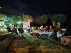 a group of people sitting at tables in front of a screen at Casale Bavi in Ortona +65 photos