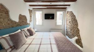 a bedroom with a bed and a tv on the wall at Maison Studio in Chioggia