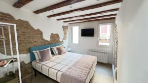 a bedroom with a bed and a brick wall at Maison Studio in Chioggia +21 photos