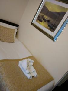 a hotel room with a bed with towels on it at The Waverley Guest House in Inverness