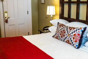 a bed with a red blanket and a pillow on it at The Marshall House, Historic Inns of Savannah Collection in Savannah