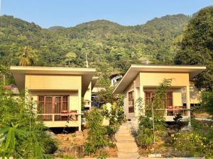 two houses with mountains in the background at O Zen Resort in Ko Man Nai