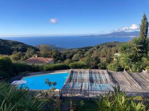 a view of a swimming pool and the ocean at Charmante Maison Vue mer Panoramique à Coti-Chiavari in Coti-Chiavari