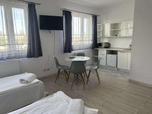 a room with a kitchen and a table and chairs at VESTA Apartamenty P23 in Szczecin