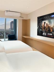 a bedroom with a bed and a tv on the wall at Ancient City Garden Luxury Residence Xian in Xi'an