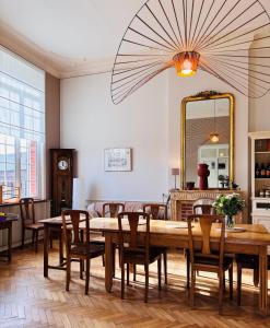 a dining room with a table and chairs and a mirror at Ferme De Bonavis in Banteux