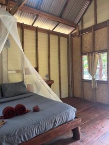 a bedroom with a bed with a mosquito net at Koh Jum Ozone Resort in Ko Jum