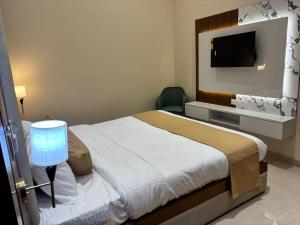 a bedroom with a bed and a flat screen tv at Hotel Ramya in Varanasi