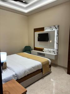 a bedroom with a bed and a flat screen tv at Hotel Ramya in Varanasi +1 photo