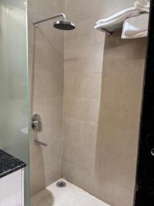 a shower with a glass door with a toilet at Hotel Ramya in Varanasi