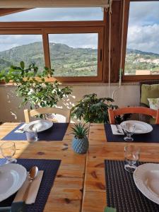 a wooden table with plates and utensils on it at B&B Il Belvedere 2 in Guardialfiera