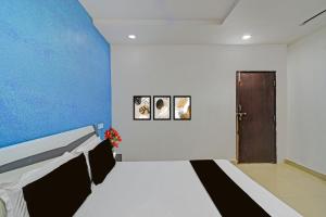 a room with a bed and a blue wall at Hotel O Madhuram Lodge in Siddipet