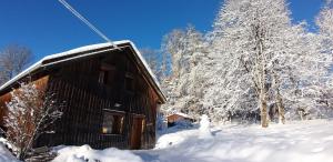 a snowman is standing next to a cabin at Gite du Brin d'Herbe in Pontarlier