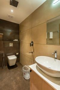 a bathroom with a sink and a toilet at The Continental Suites in Kozhikode