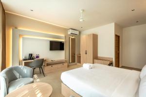 a hotel room with a bed and a desk and chair at The Continental Suites in Kozhikode